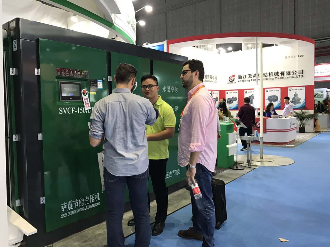 薩震節能空壓機工作人員與外國友人交談